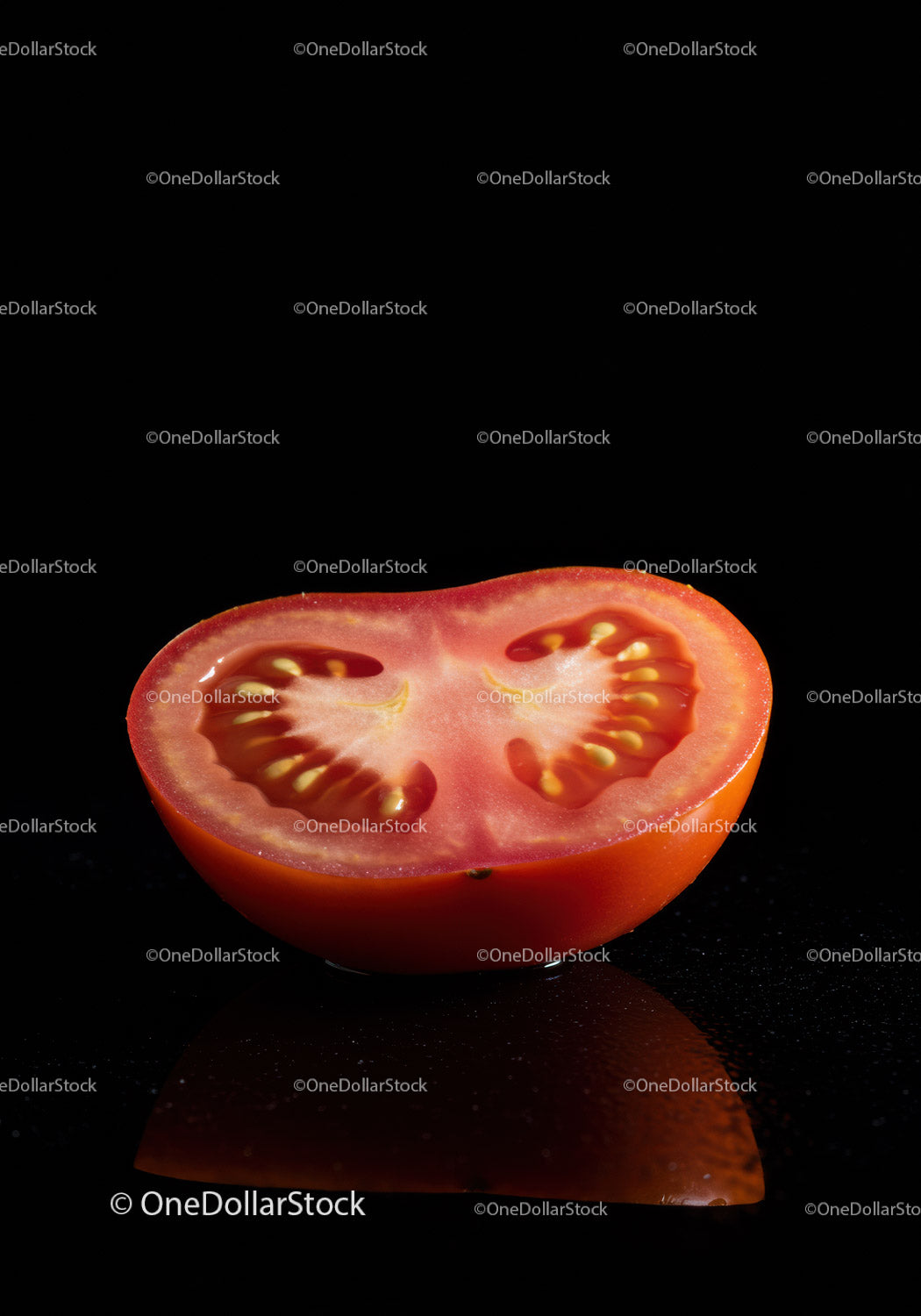 Fresh half tomato with seeds on black background