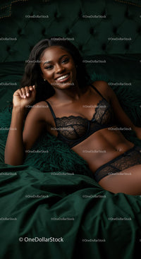 Smiling woman in elegant black lace lingerie relaxing on bed