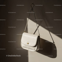 Minimalist white leather crossbody bag hanging on wall