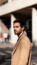 Confident man in camel coat walking in city street
