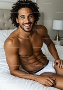 Smiling man relaxing on bed in bright bedroom