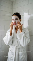 Young Woman Applying Facial Mask in Spa Setting
