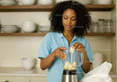 Young Woman Preparing Banana Smoothie in Modern Kitchen