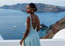 Elegant woman in blue dress overlooking ocean bay