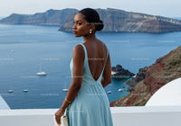 Elegant woman in blue dress overlooking ocean bay