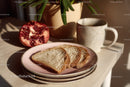 Fresh Sliced Bread with Pomegranate and Coffee Mug on Wooden Table
