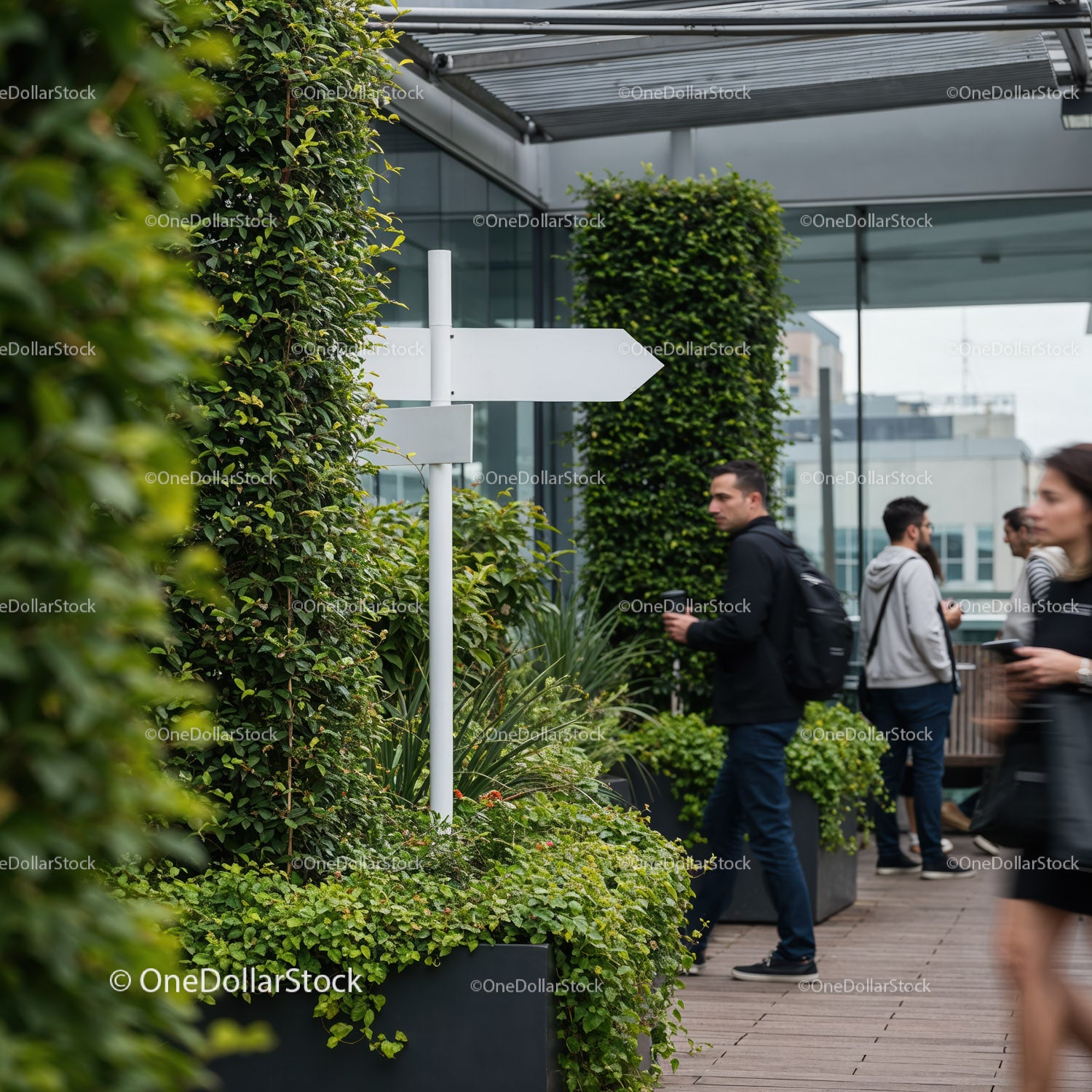 People walking by greenery lined modern rooftop terrace