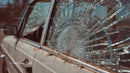 Abandoned Vintage Car with Broken Glass at Sunset