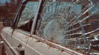 Abandoned Vintage Car with Broken Glass at Sunset