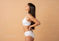Serene Woman in White Sportswear Posing in Minimalist Studio