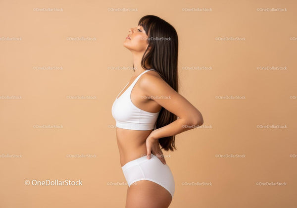 Serene Woman in White Sportswear Posing in Minimalist Studio