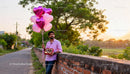 Man Holding Heart-Shaped Balloons and Chocolates Outdoors