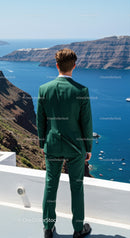 Man in green suit admiring sea cliff view
