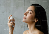 Woman Spraying Water on Face for Refreshing Skincare Routine