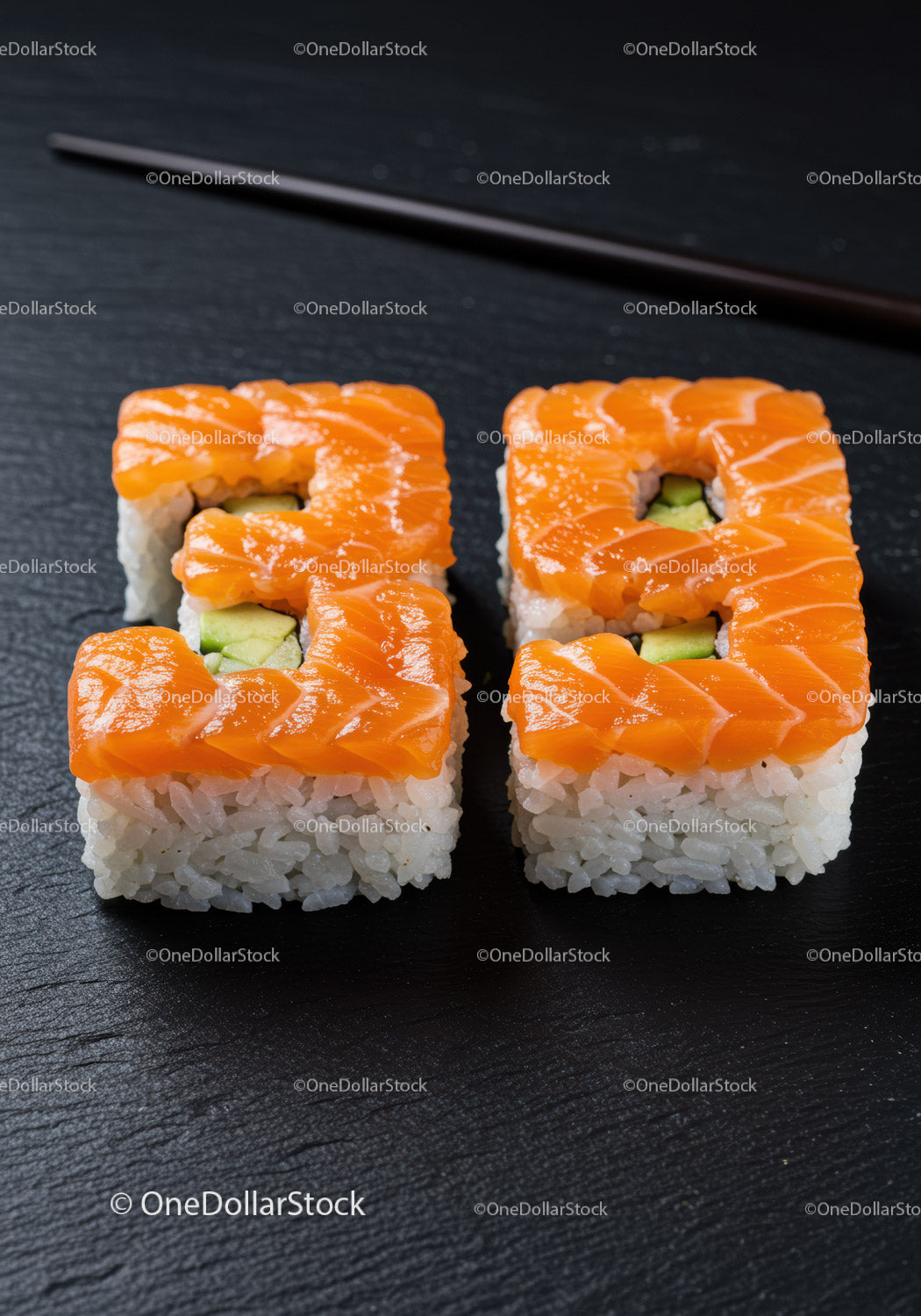 Fresh salmon avocado sushi rolls on black slate plate