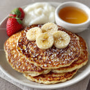 Stack of Fluffy Pancakes with Banana Slices Strawberries and Honey