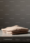 Minimalist Beige Sweater Folded on Concrete Surface