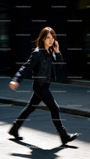 Young woman walking confidently while talking on phone