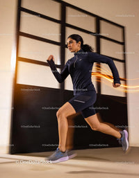 Athletic young woman running indoors in black sportswear