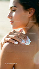 Woman Applying Moisturizer on Shoulder in Soft Light