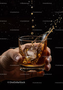 Hand Holding Glass of Whiskey with Splashing Ice Cubes