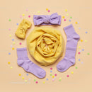 Pastel baby accessories with confetti on beige background
