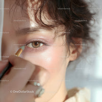 Close-up of Woman Applying Eye Shadow with Cosmetic Brush