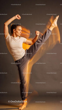 Focused young woman executing dynamic high kick