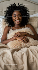 Smiling woman relaxing comfortably in bed with cozy pillow