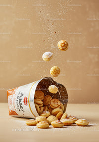 Mini pancake cereal spilling from packaging with sugar dust