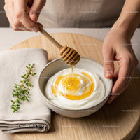 Honey Dripping into Yogurt with Fresh Herbs on a Wooden Serving Board