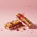 Crispy granola bars with berry filling on pink background