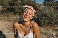 Joyful Woman with Curly Hair Laughing Outdoors in Summer