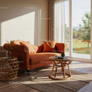 Cozy orange sofa with cushions near sunny window