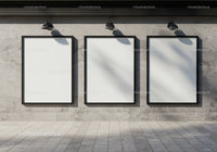 Three blank vertical posters on gray concrete wall