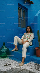 Elegant Woman in Traditional Attire Against a Vibrant Blue Wall