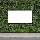 Blank billboard surrounded by lush green plants wall