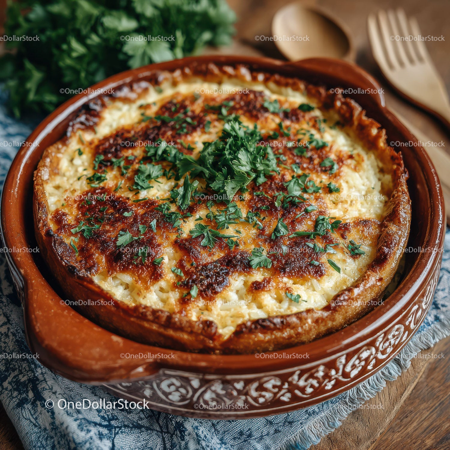 Serowe danie pieczone z dodatkiem świeżej pietruszki w naczyniu terakotowym