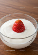 Fresh strawberry nestled in creamy yogurt bowl