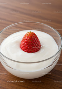 Fresh strawberry nestled in creamy yogurt bowl