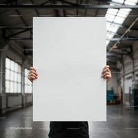 Person holding a blank white poster in industrial space