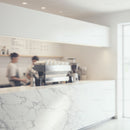 Modern coffee bar with marble countertop and baristas