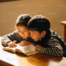 Two children deeply focused on reading a book together