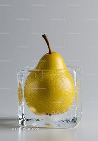 Ripe pear frozen in transparent ice cube