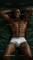 Relaxed young man lying on bed with confident smile