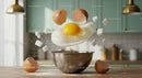 Egg cracking and sugar cubes falling over mixing bowl