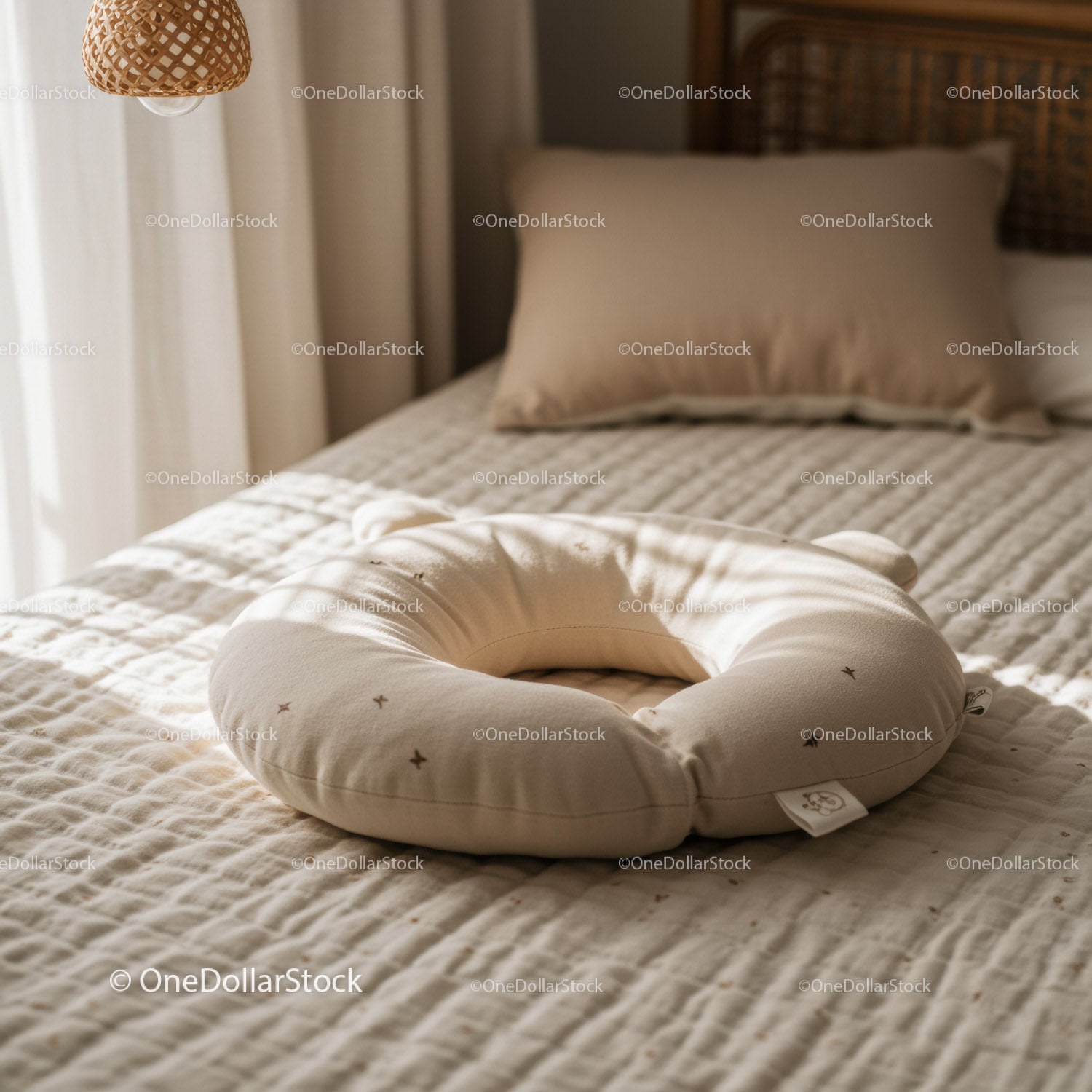 Soft beige nursing pillow on cozy bed in warm light