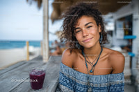 Young Woman Smiling with Berry Juice at Beachside Outdoor Cafe