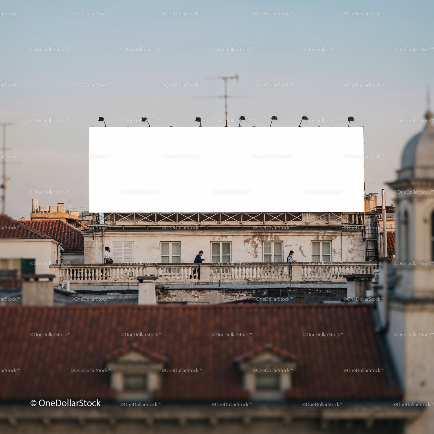 Ludzie przechodzący obok dużego, pustego billboardu na dachu miasta