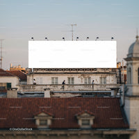 People walking past large blank rooftop billboard in city